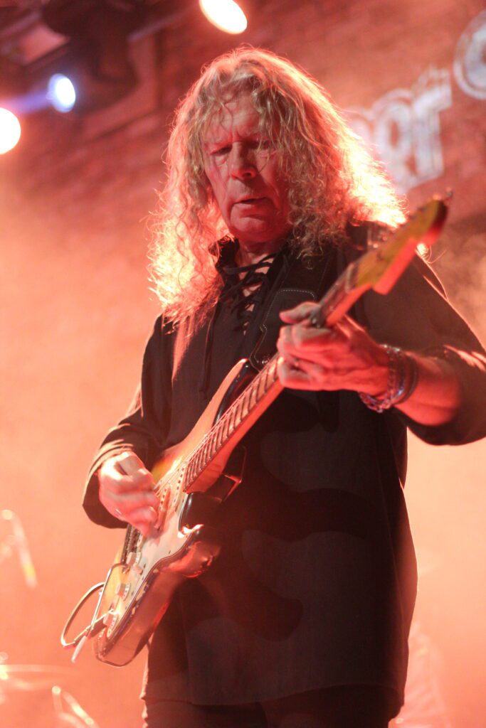 Lead guitarist of Deeper Purple performing a solo under warm stage lighting at The Brook Southampton