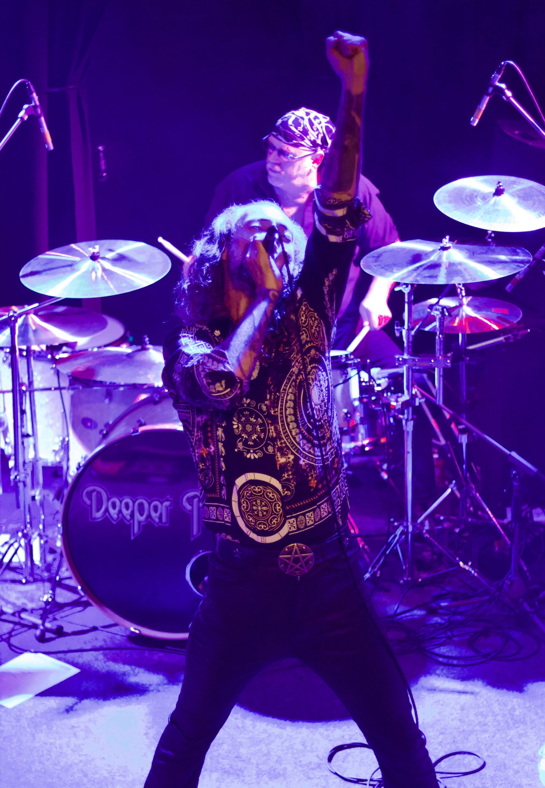 Lead singer raising fist during powerful live performance with drummer behind at The Brook Southampton