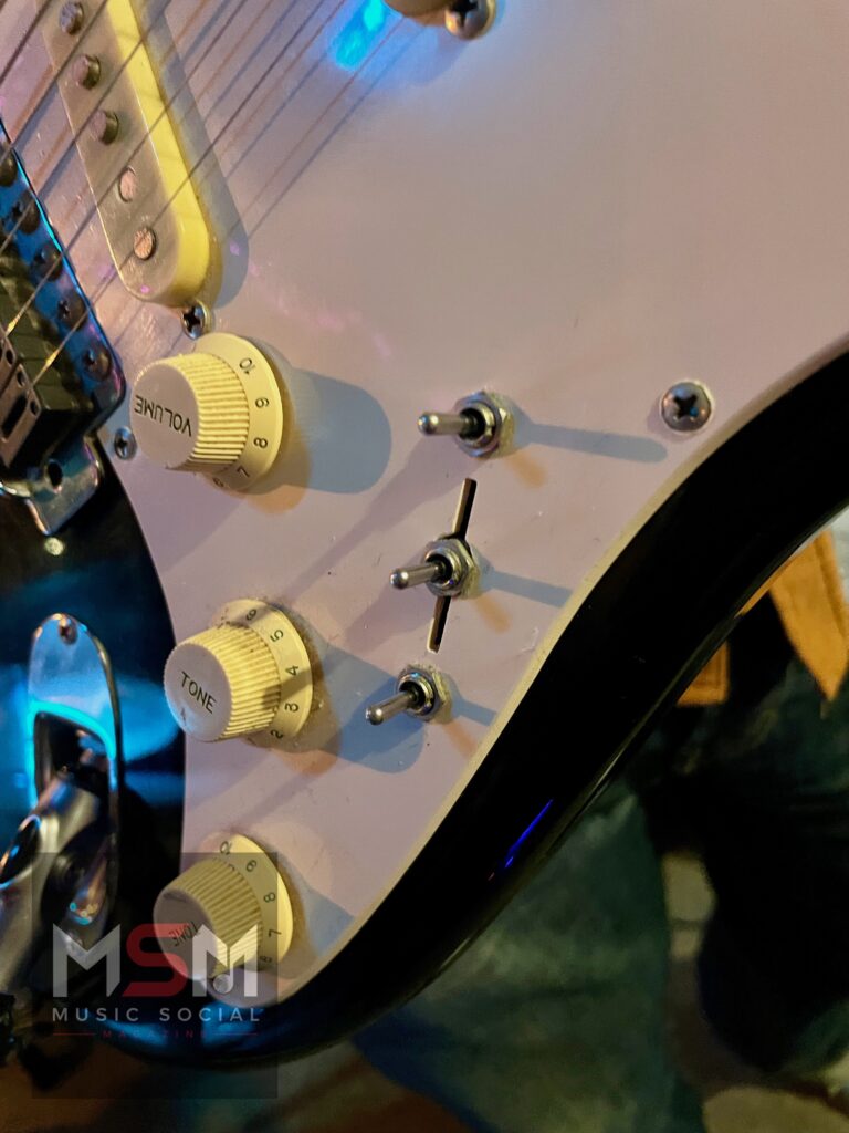 Close-up detail of Mick’s customised ‘Frankenstein’ Squier guitar during The Blues Social at The Platform Tavern, showing the unique switch layout and controls under stage lighting.