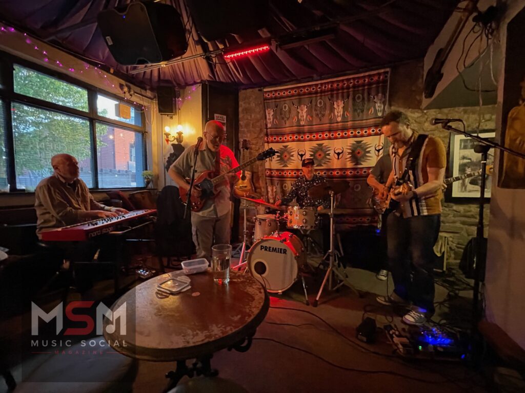 Wide view of The Blues Social live music night at The Platform Tavern in Southampton featuring Pete Harris, Mick Downs, Mike Jessop, Rob Marshall and Bill Smudge performing beneath warm stage lighting inside the historic dockside pub.