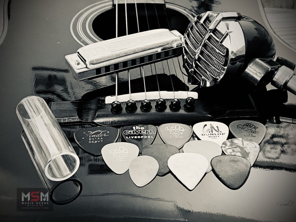 Black and white close-up of guitar strings, harmonica and guitar picks for MSM “So You Wanna Build A Band” feature