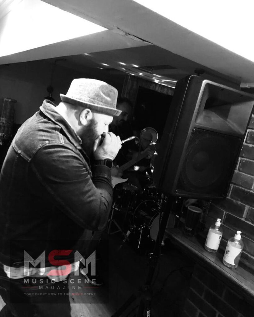 Bryan from Music Scene Magazine singing into a microphone during rehearsal or live performance for the “So You Wanna Build a Band?” series.