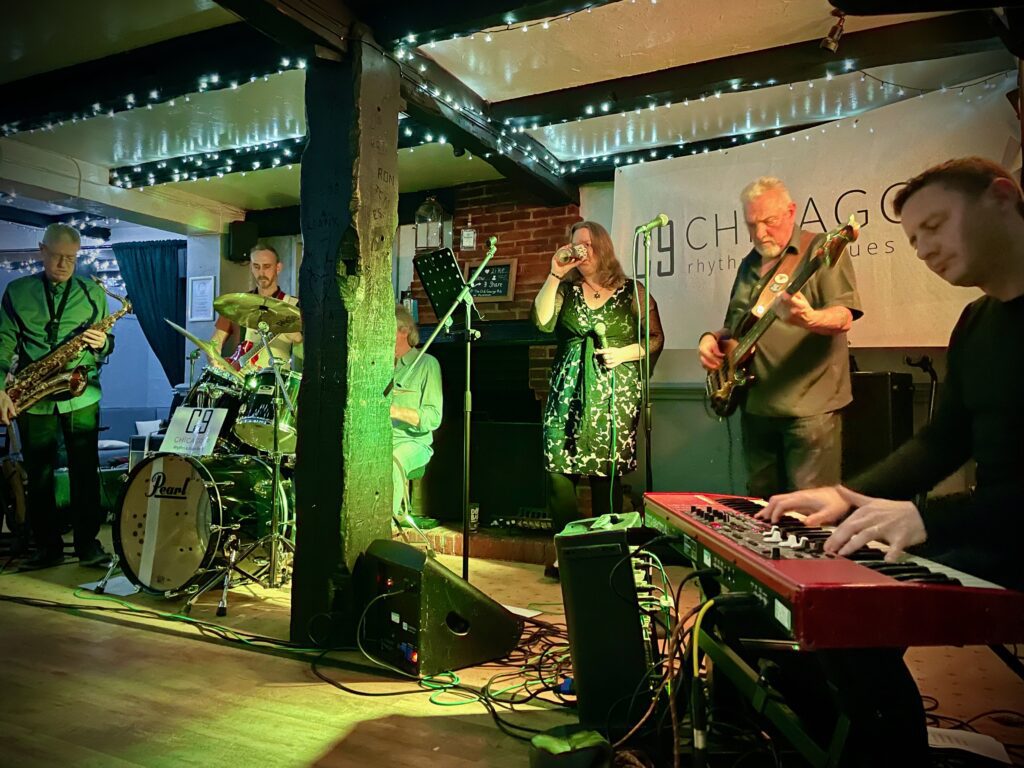 Chicago 9 performing live as a full band during a South Coast rhythm and blues performance, featuring all six members on stage.